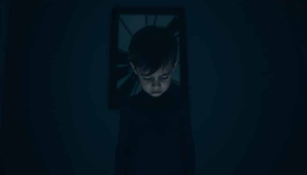 A solitary child, shoulders hunched, standing in a dimly lit, shadowy room. Faint traces of a fractured mirror on the wall behind, reflecting a distorted, fragmented self-image. Soft, muted tones of grays and blues cast a melancholic, pensive atmosphere. Harsh lighting from an unseen source illuminates the child's pained expression, highlighting the emotional weight and long-lasting psychological scars. The scene evokes a sense of isolation, inner turmoil, and the lasting impact of narcissistic parental neglect.